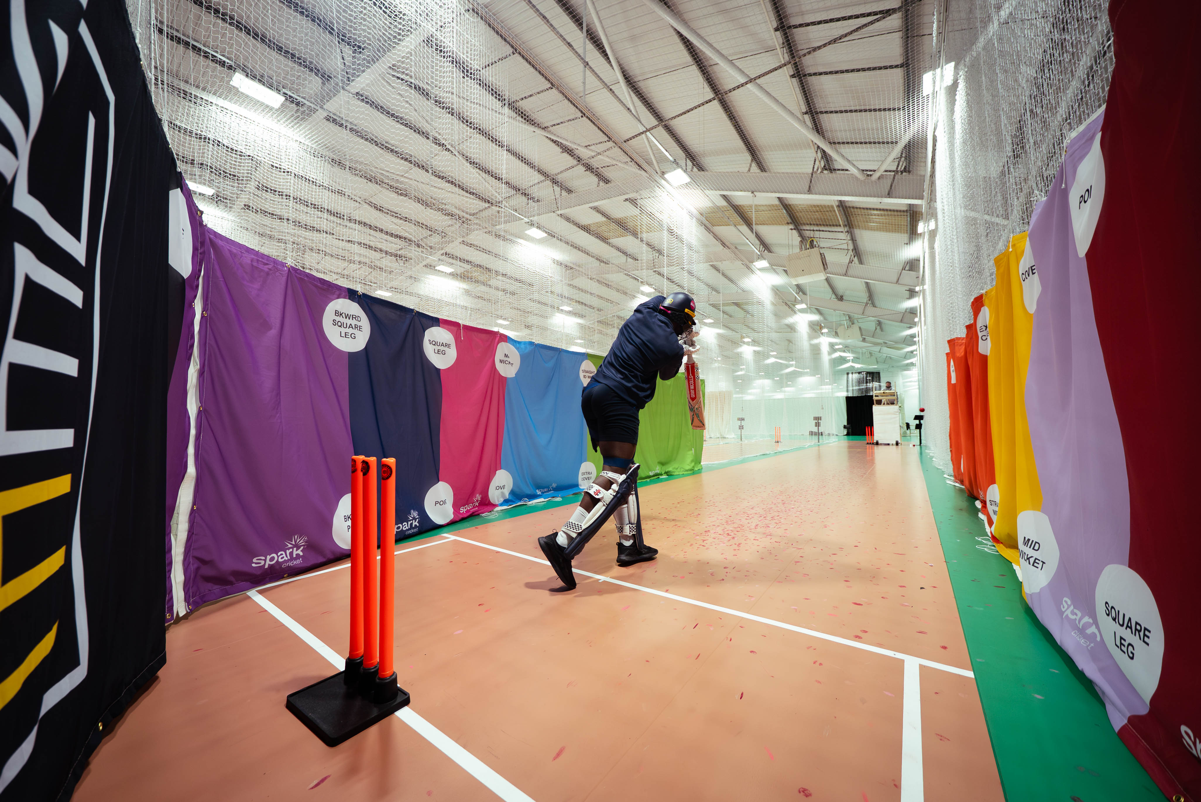 A player batting inside a SPARK net battles lane